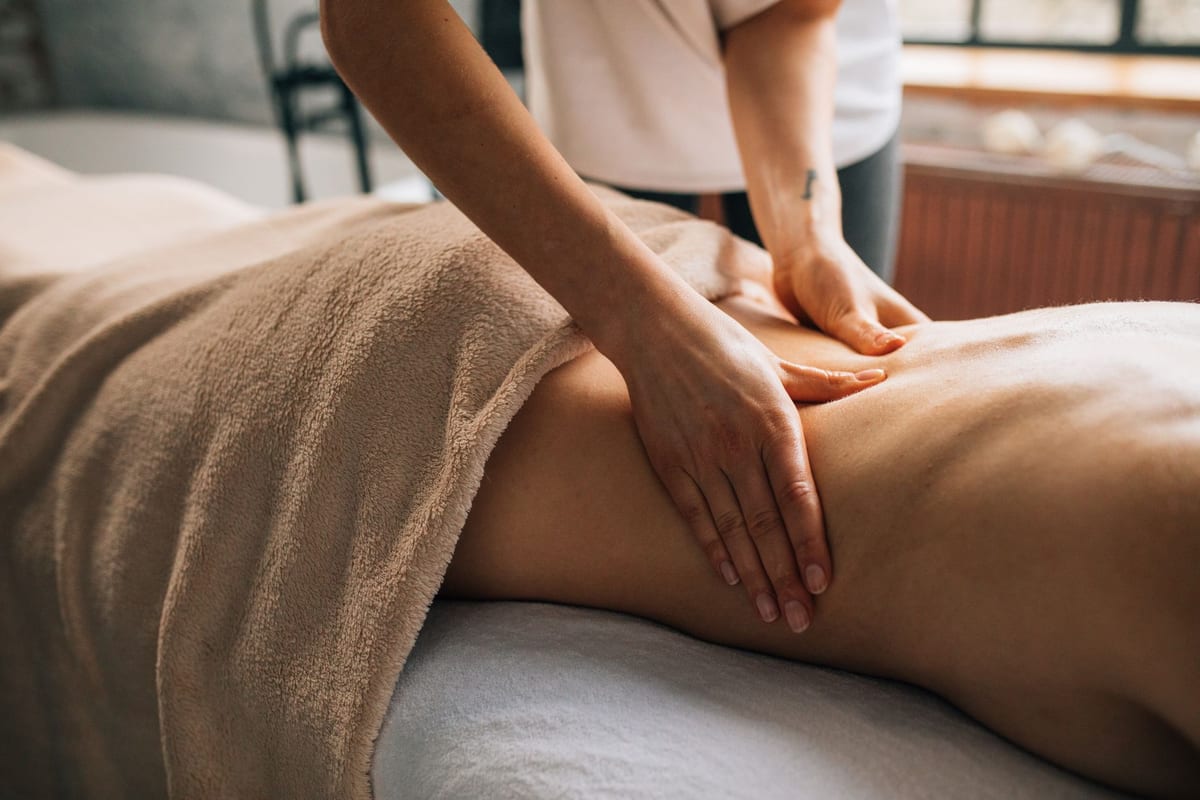 A registered massage therapist working along a patient's shoulders