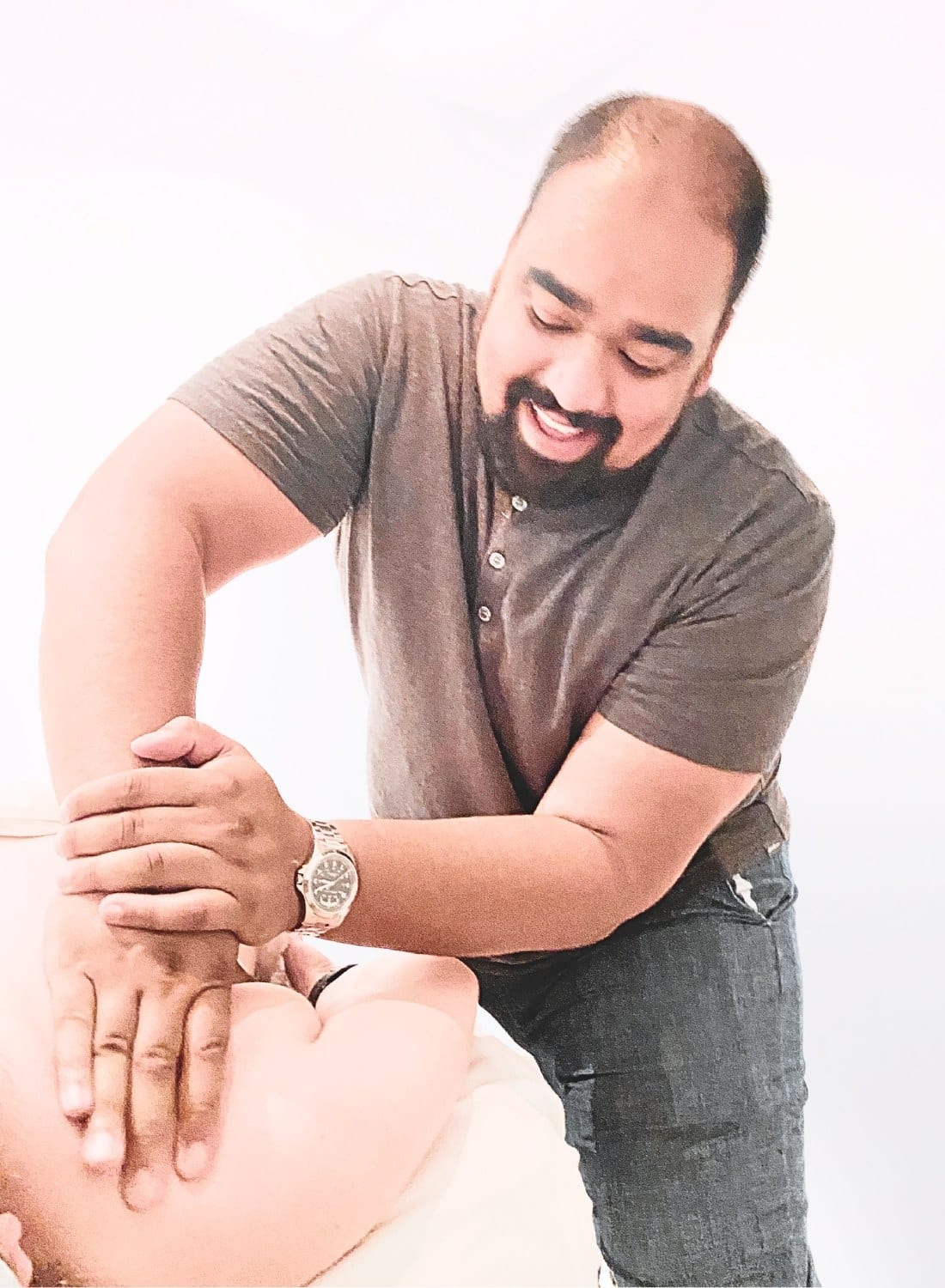 A registered massage therapist working on a patient's shoulder