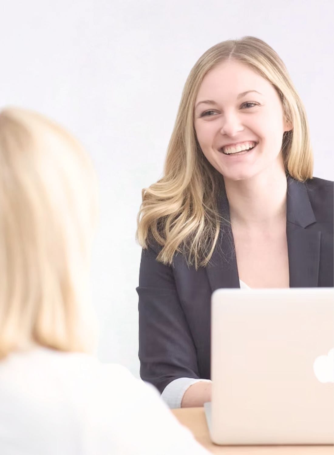 A practitioner in consultation with a patient across a desk