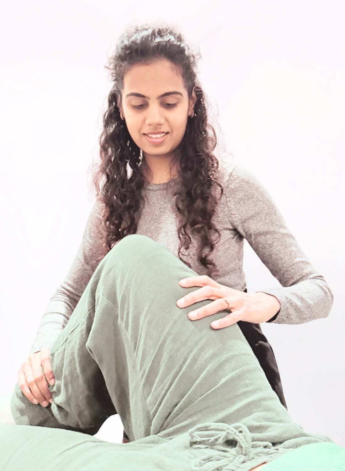 A physiotherapist guiding a patient's bent knee through a supported movement